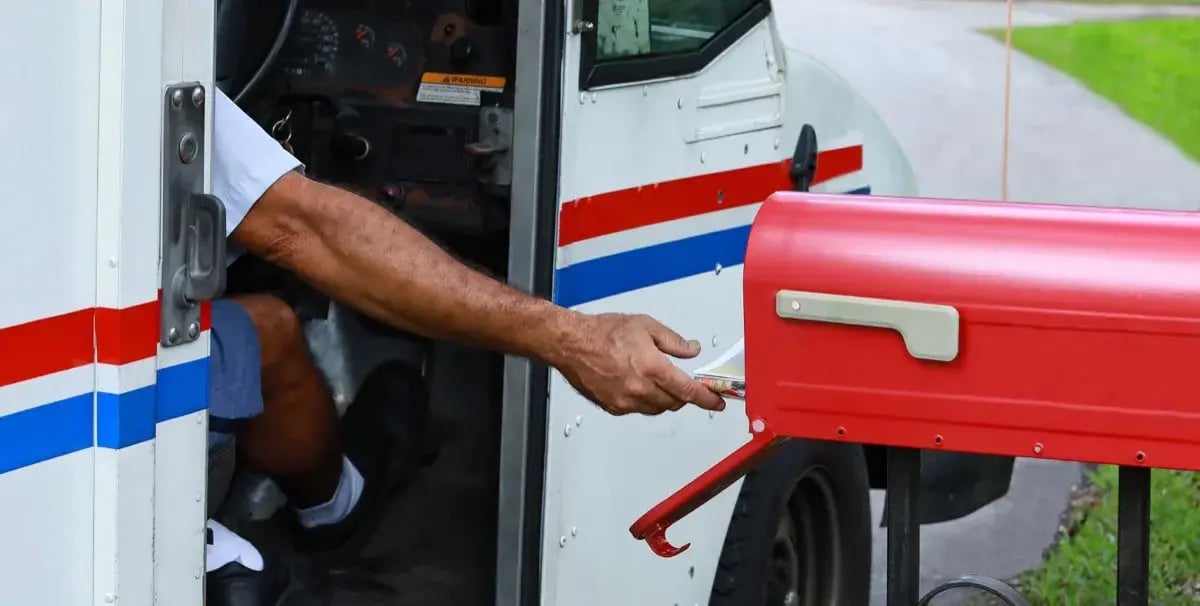 usps-postman-delivering-mail-to-mailbox